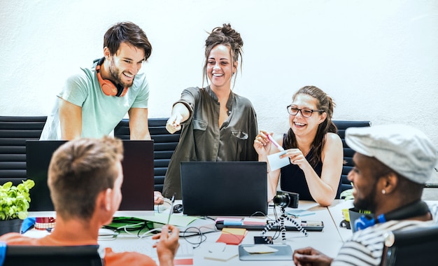 Foto jóvenes empleados grupo de trabajadores con computadora en el estudio de inicio