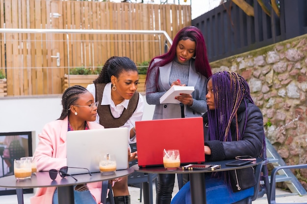 Jóvenes empresarias de etnia negra en una reunión de negocios en una cafetería