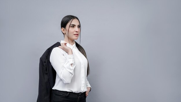 Jóvenes empresarias sosteniendo el hombro de la capa mirando a la izquierda vistiendo la camisa blanca modelo paquistaní indio