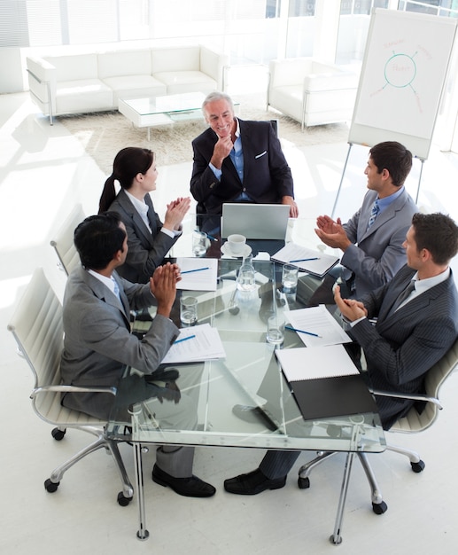 Foto jóvenes empresarios aplaudiendo a su gerente