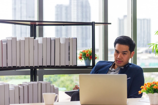 Jóvenes empresarios asiáticos mirando el libro de citas en la oficina