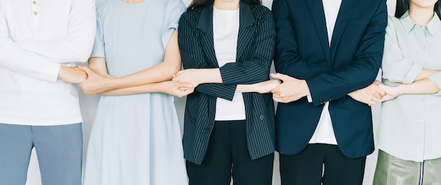 Jóvenes empresarios asiáticos se toman de la mano para mostrar solidaridad