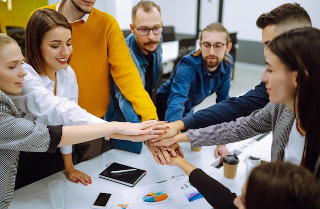 Jóvenes empresarios demostrando unidad con sus propias manos