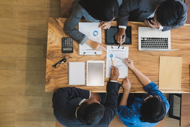 Jóvenes empresarios y empresarios con una reunión alrededor de la mesa en la oficina