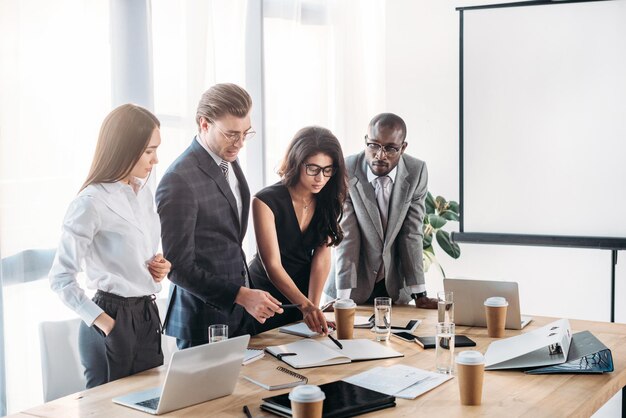 Jóvenes empresarios multiculturales con reunión de negocios en la oficina