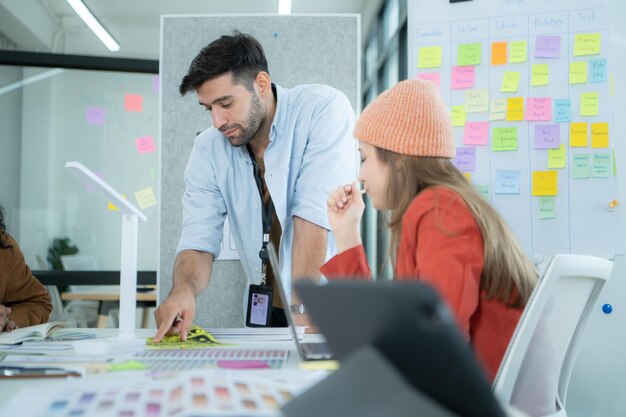 Jóvenes empresarios multiétnicos que trabajan juntos en una oficina moderna Colaboran en el diseño