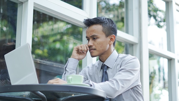 Los jóvenes empresarios piensan mientras se sientan con el portátil