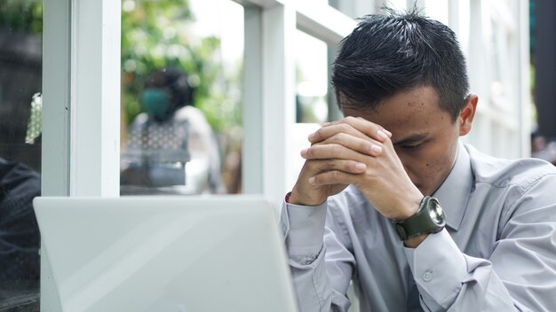 Los jóvenes empresarios piensan mientras se sientan con el portátil