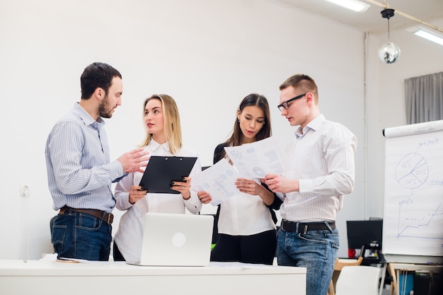 Jóvenes empresarios que trabajan en equipo reunidos en la oficina