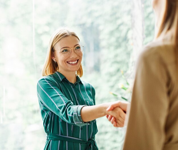 Jóvenes empresarios se reúnen en la oficina se dan la mano se dan la mano trabajo en equipo acuerdo de contrato de grupo