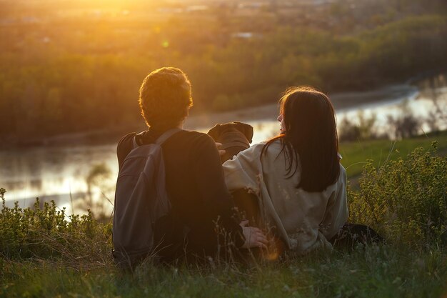 jóvenes enamorados un chico y una chica están sentados en un banco alto del río con su perro grande