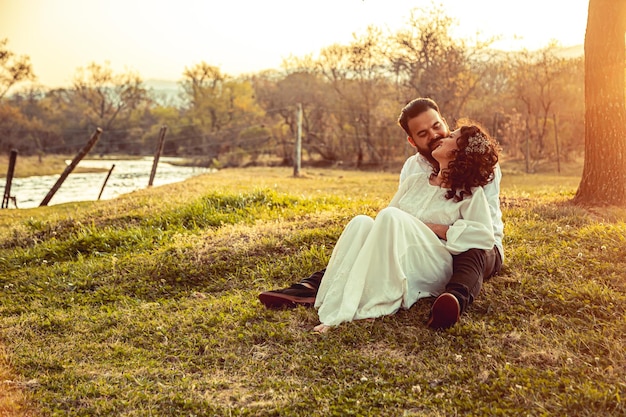 Jóvenes enamorados sentados en un parque al atardecer