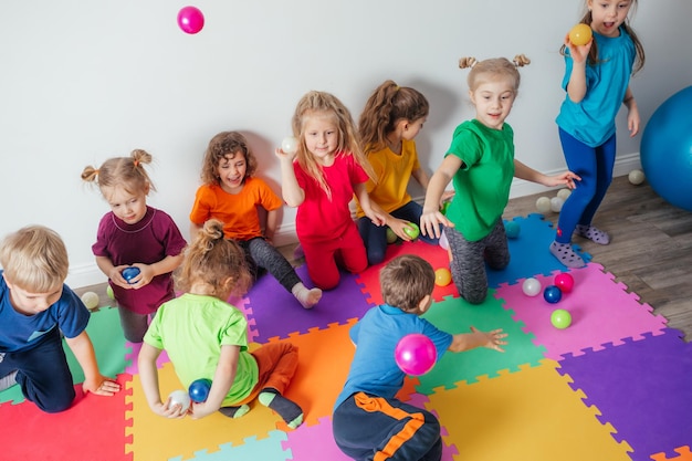 Jóvenes enérgicos tirando muchas bolas de colores