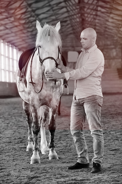 Los jóvenes en un entrenamiento de caballos en una arena de madera