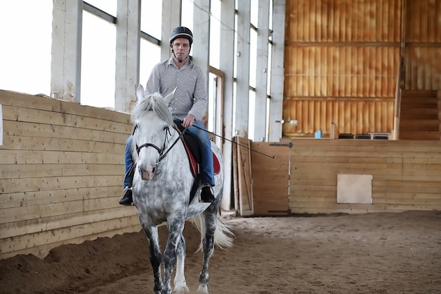 Los jóvenes en un entrenamiento de caballos en una arena de madera