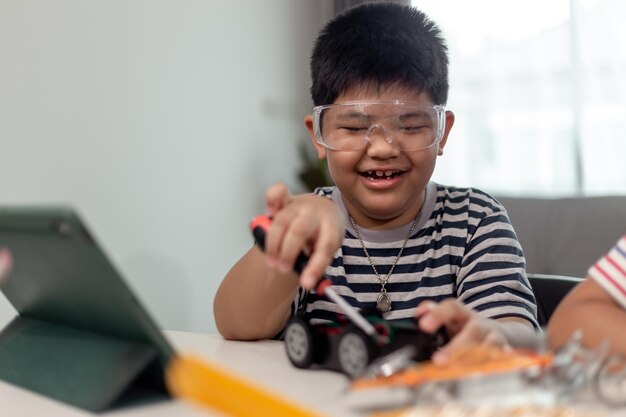 Jóvenes estudiantes asiáticos aprenden a distancia en línea en casa en codificación de automóviles robóticos y cables de placa electrónica en STEM STEAM matemáticas ingeniero de ciencia tecnología código de computadora en robótica para niños