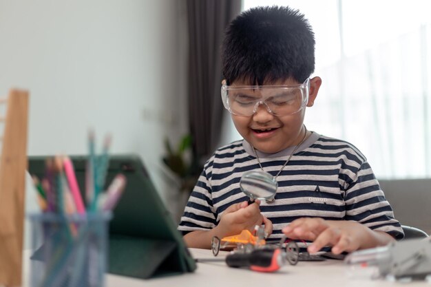 Jóvenes estudiantes asiáticos aprenden a distancia en línea en casa en codificación de automóviles robóticos y cables de placa electrónica en STEM STEAM matemáticas ingeniero de ciencia tecnología código de computadora en robótica para niños