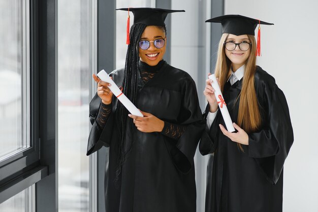 Jóvenes estudiantes en bata celebrando su graduación