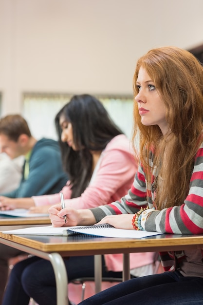 Foto jóvenes estudiantes escribiendo notas en el aula