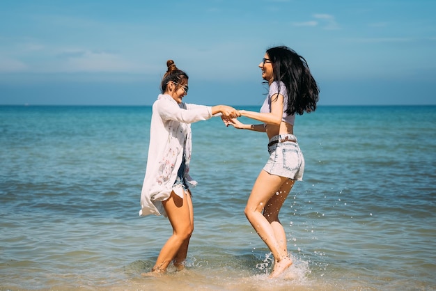 Jóvenes felices bailando en la playa de vacaciones