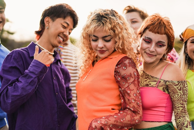 Jóvenes felices y diversos divirtiéndose bailando durante el concierto de música de verano al aire libre