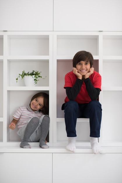 los jóvenes felices se divierten mientras posan en un estante en un nuevo hogar moderno