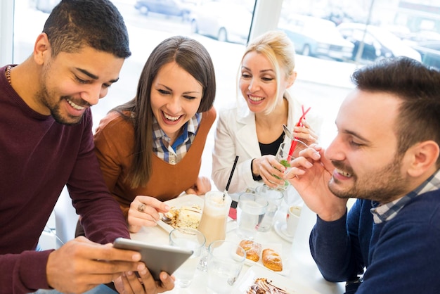 Jóvenes felices divirtiéndose en un pastel de café