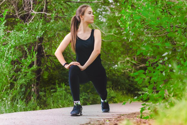 Jóvenes en forma caucásica chica haciendo ejercicio en el parque antes de correr Copia espacio