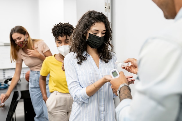 Los jóvenes hacen fila para medir la temperatura corporal