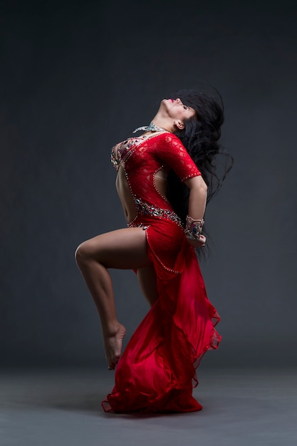 Jóvenes hermosas mujeres orientales exóticas realizan danza del vientre en vestido rojo étnico