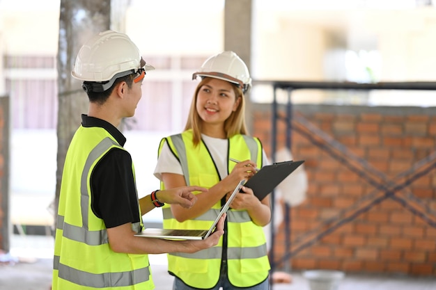 Jóvenes ingenieros supervisan juntos el progreso del proyecto de construcción Concepto de construcción de ingenieros industriales