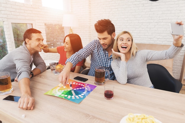 Foto los jóvenes juegan un juego de mesa con dados y fichas.