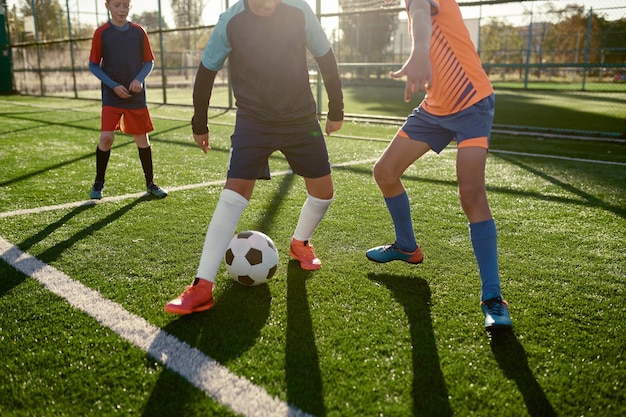 Foto jóvenes jugando fútbol en el campo de entrenamiento para niños