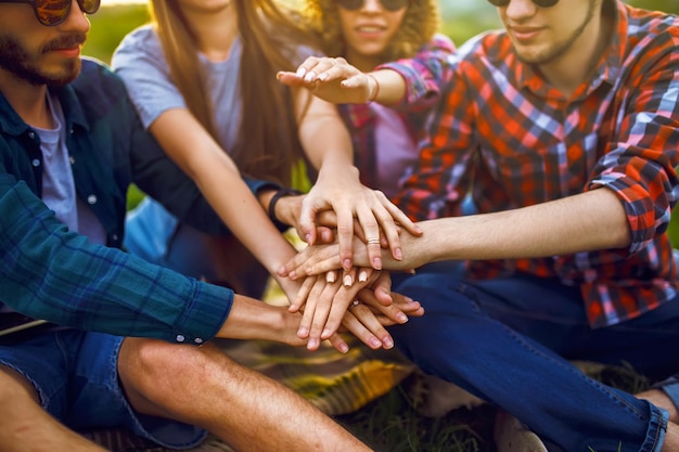 Jóvenes juntando sus manos Amigos con pila de manos mostrando unidad y trabajo en equipo