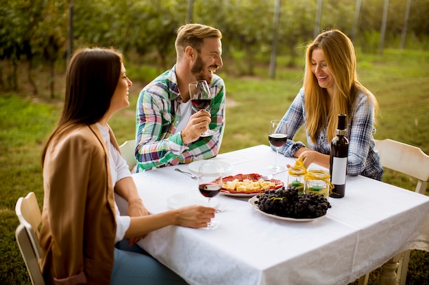 Jóvenes junto a la mesa en el viñedo