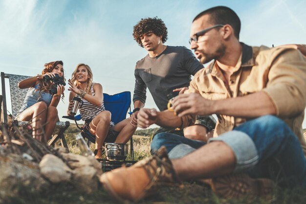 Los jóvenes se lo pasan bien en el campamento en la naturaleza. Están descansando, riendo y hablando felices de estar juntos.