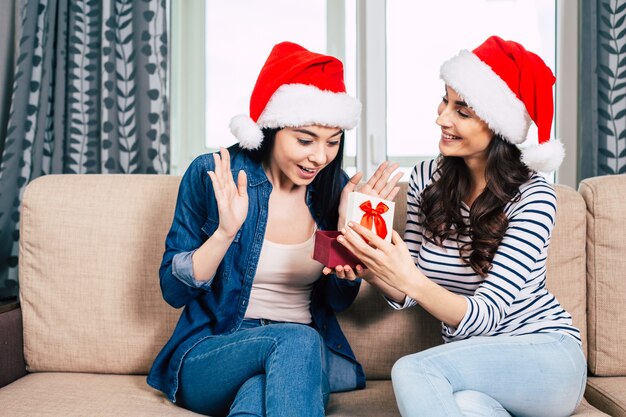 Jóvenes mujeres hermosas felices con sombreros de Santa