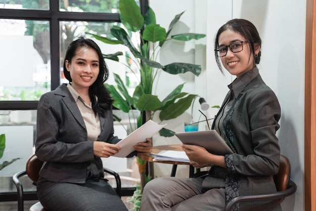 Jóvenes mujeres de negocios asiáticas reunidas en un café