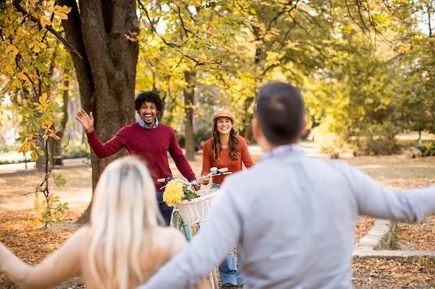 Jóvenes multirraciales caminando en el parque de otoño y divirtiéndose