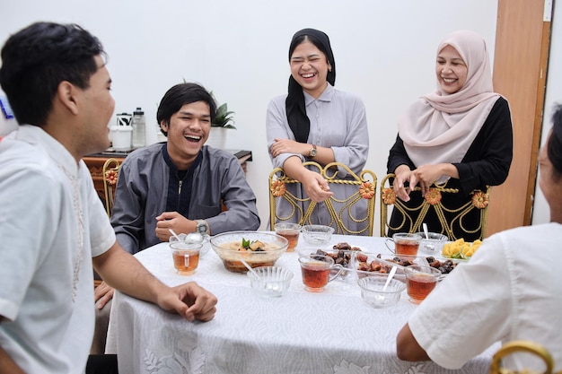 Jóvenes musulmanes asiáticos cenando y ayunando juntos en casa durante el ramadán