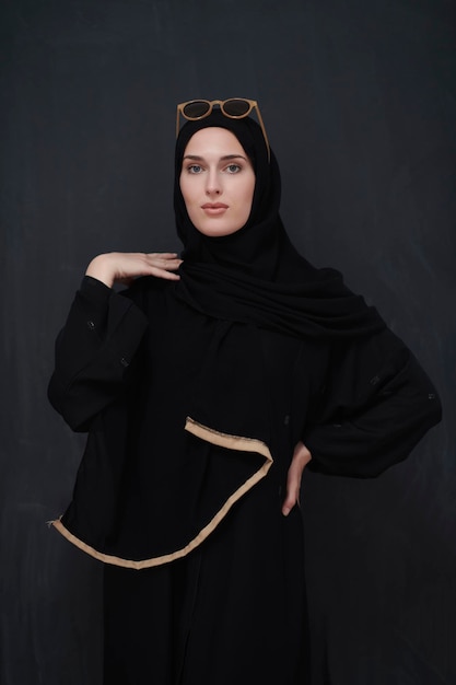 Jóvenes musulmanes con ropa tradicional o abaya y gafas de sol posando frente a una pizarra negra. Mujer árabe que representa el estilo de vida árabe moderno, la moda islámica y el concepto de Ramadan Kareem