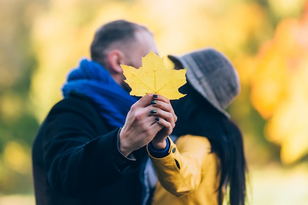 Jóvenes en el parque otoño. Árboles y hojas amarillas. Feliz concepto de familia joven.