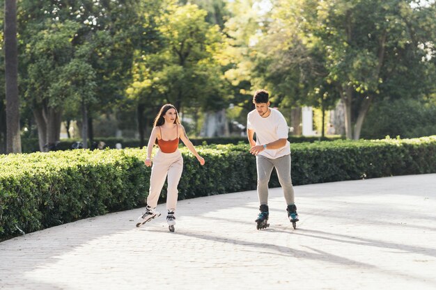 Los jóvenes patinando con patines en línea en una superficie pavimentada de un parque