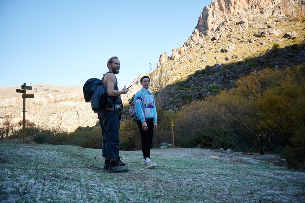 Los jóvenes de pie contra las montañas.