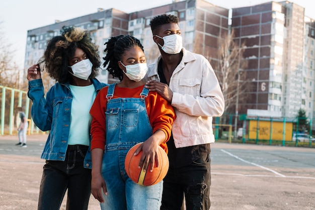 Foto jóvenes posando con máscaras médicas al aire libre