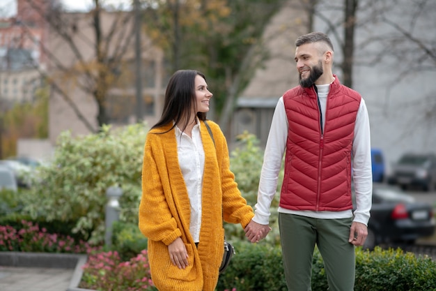 Jóvenes positivos mirándose mientras se sienten enamorados