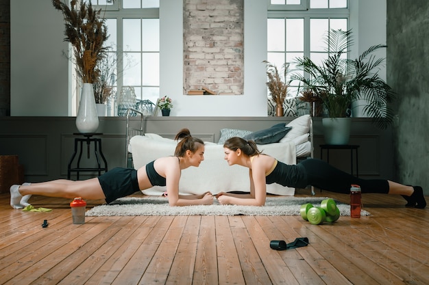 Las jóvenes practican deporte en casa.