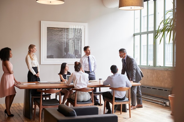 Foto jóvenes profesionales alrededor de una mesa en una reunión de negocios