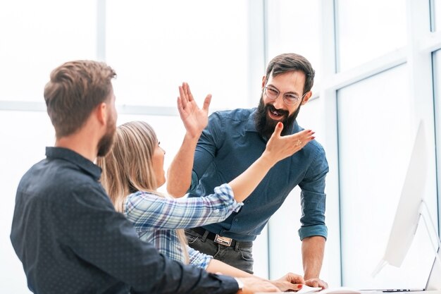 Jóvenes profesionales chocando los cinco entre sí. el concepto de trabajo en equipo