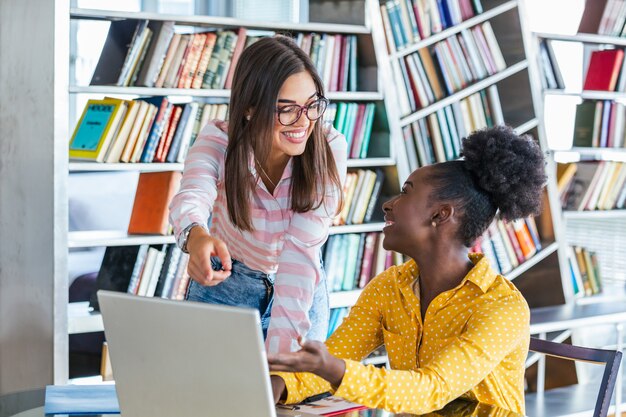 Jóvenes profesionales trabajan en compañía, usando laptop y tablet